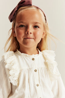 Kids' white blouse with embroidered frills