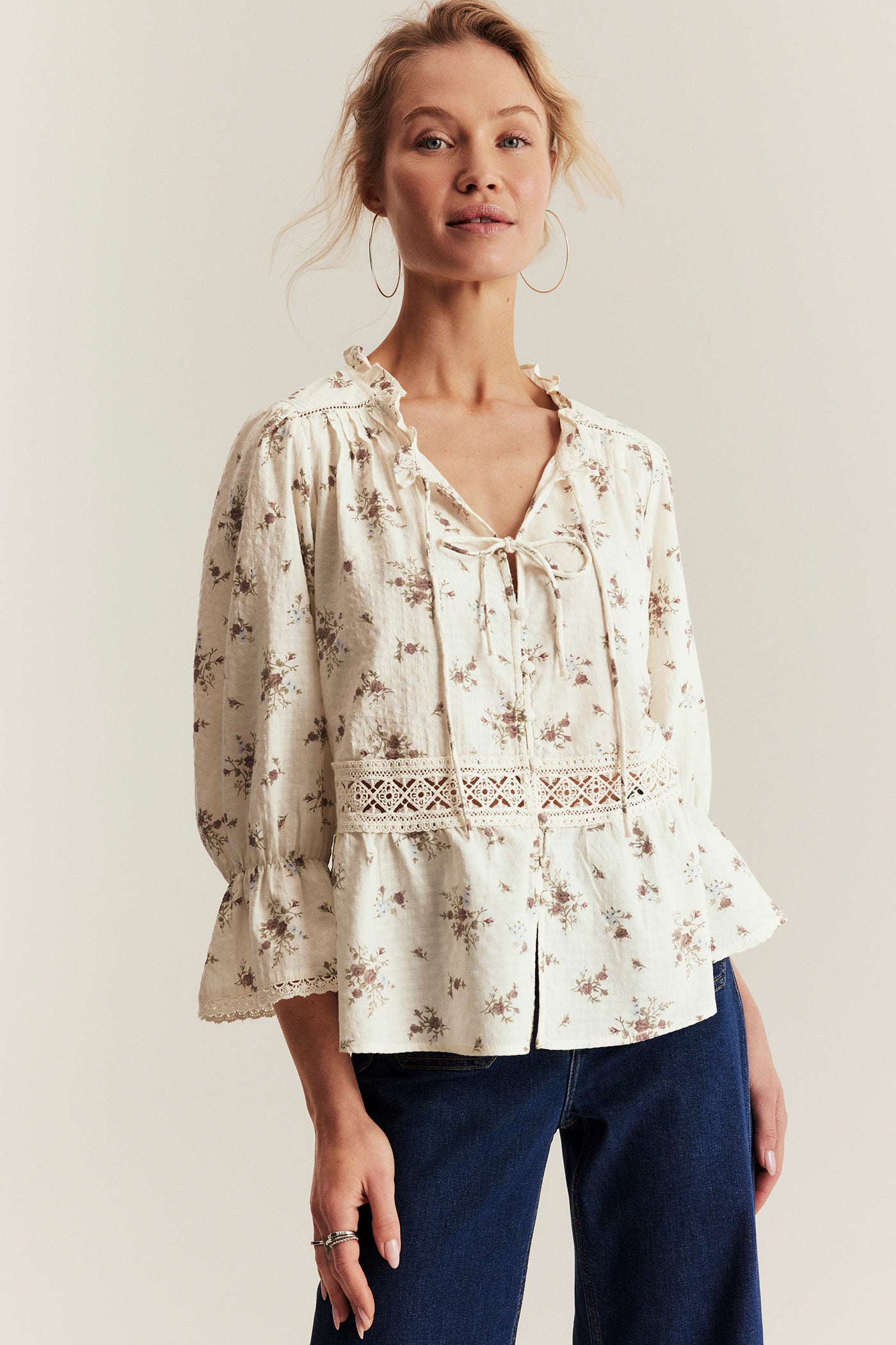 Woman wearing a floral blouse with a plain background