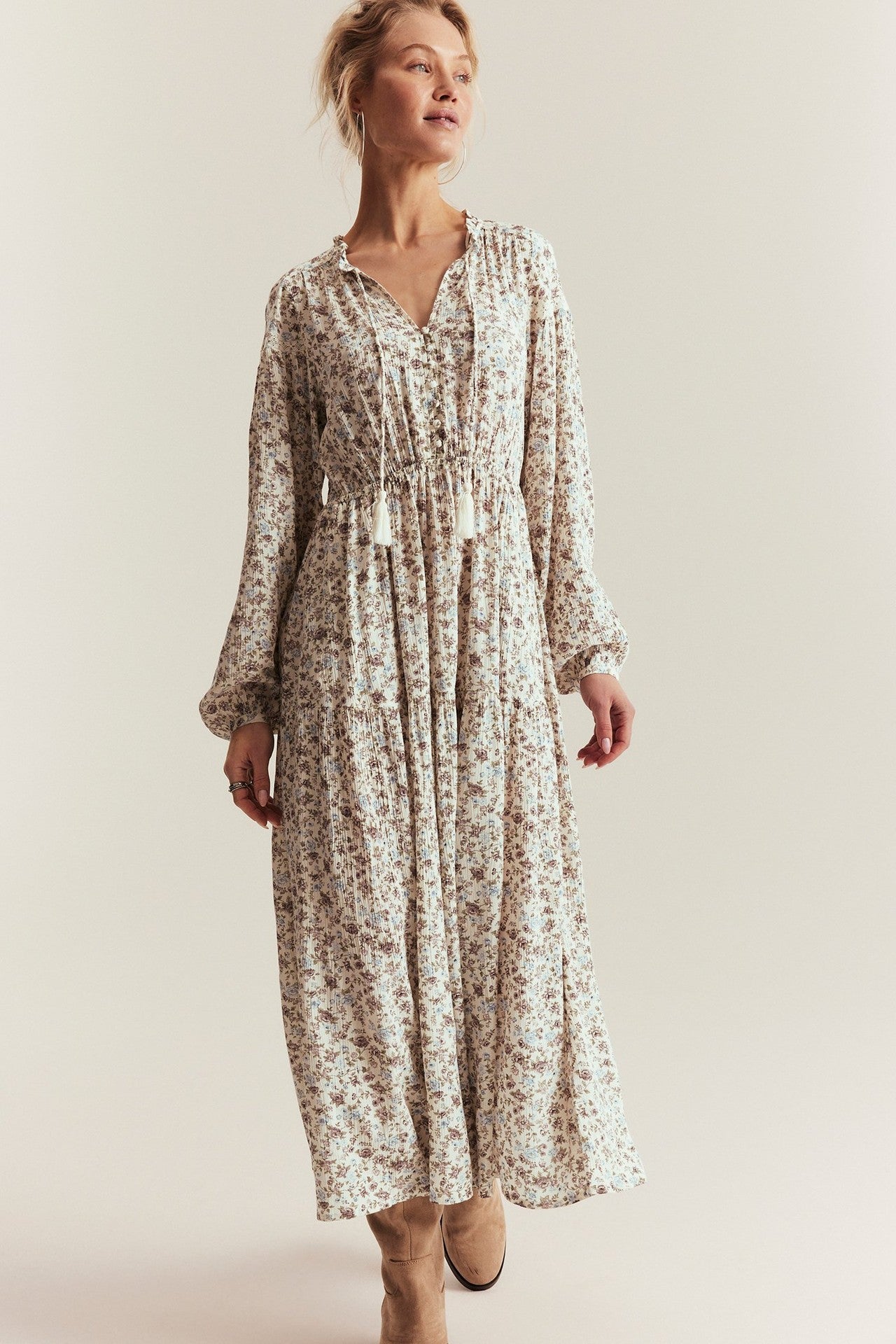 Woman wearing a floral dress against a plain background