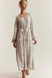 Woman wearing a floral dress against a plain background
