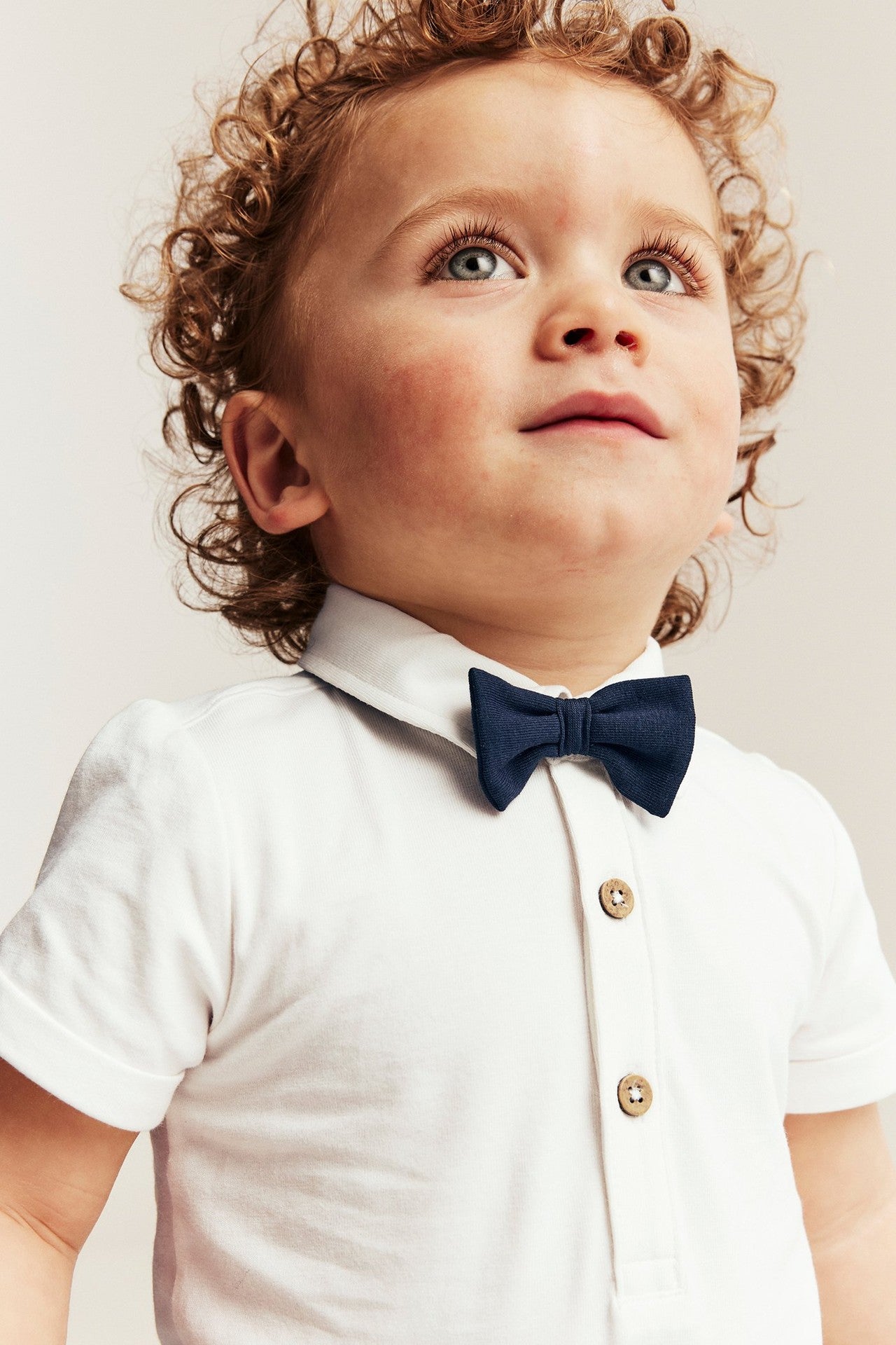 Baby white short-sleeved bodysuit with bow tie